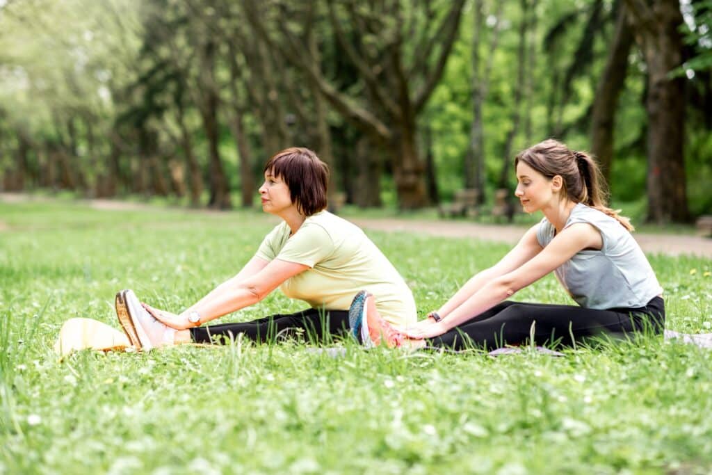 Young and elder woman doing yoga in the park